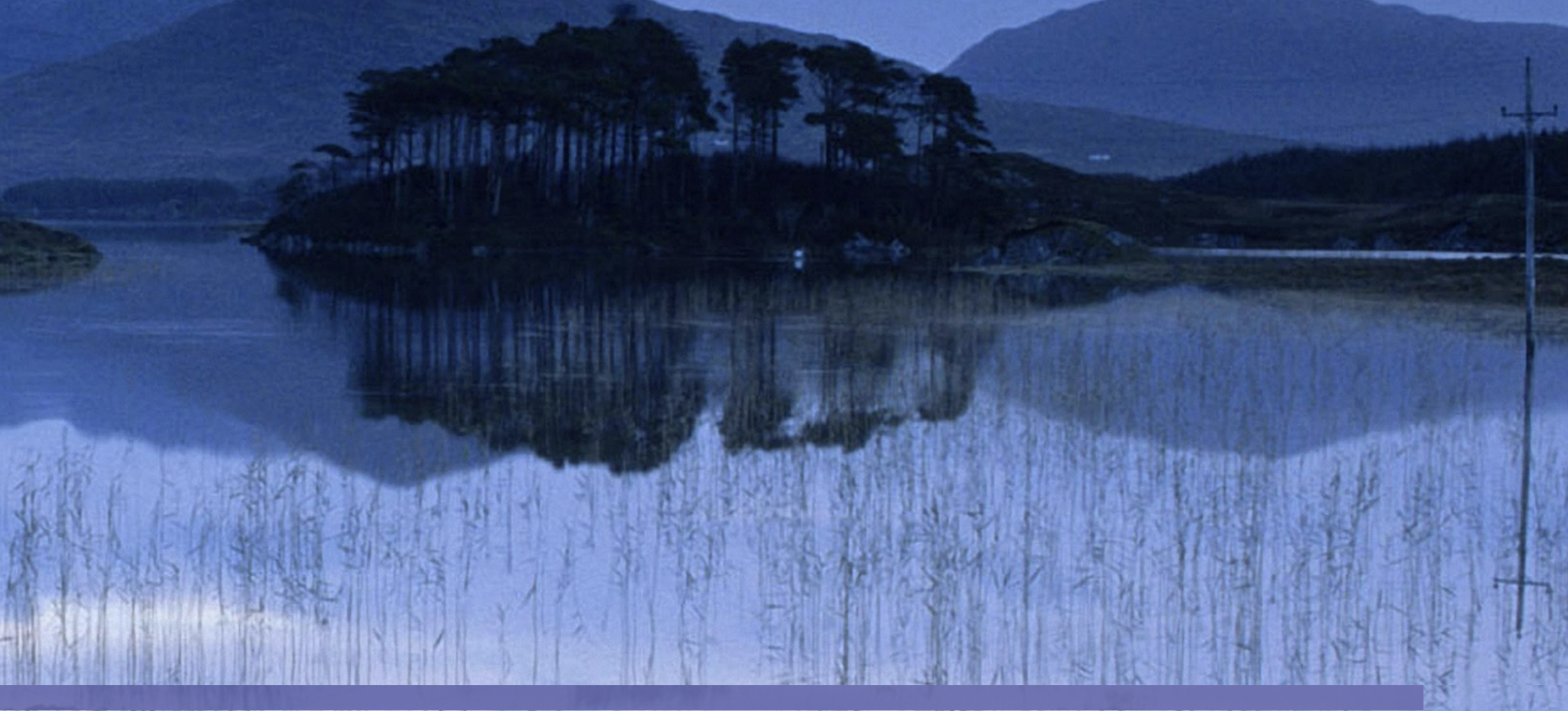 Island in lake with mountains in the background